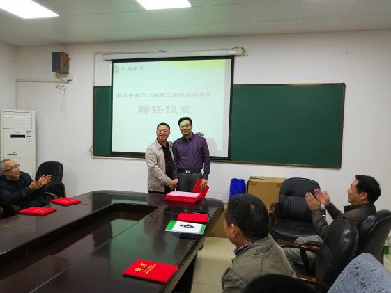 龙校长给周友明老师颁发聘书