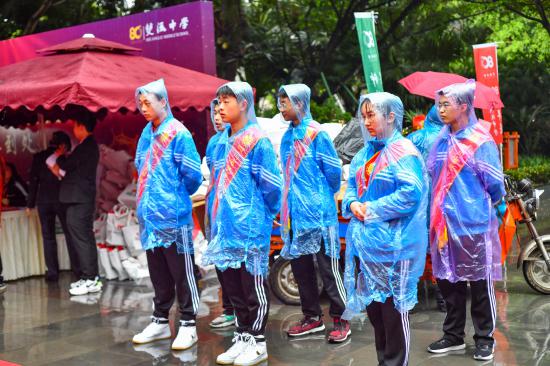 虽然下着小雨，志愿者们穿上雨衣坚守岗位